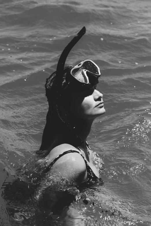 a woman is in the water with her goggles on