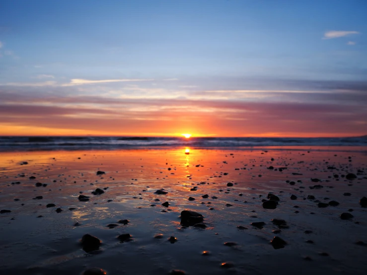 a bright, yellow and orange sunset on the beach