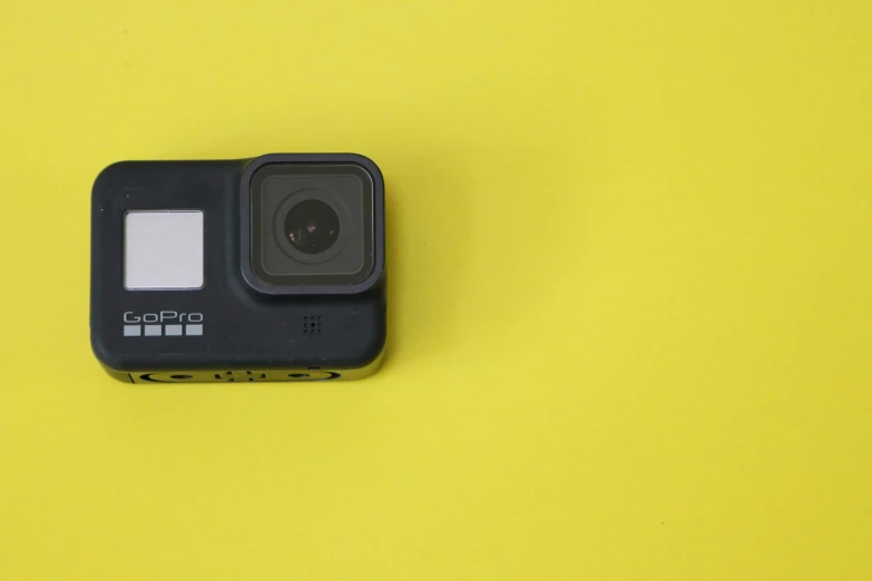 an instax camera sitting on top of a yellow surface