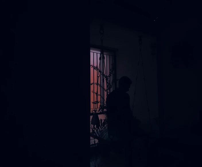 a person walking out the side of a door in a dark room