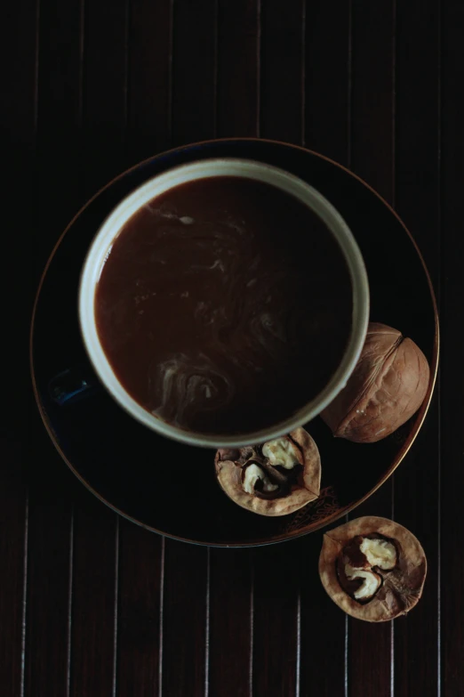 the bowl is full of dark liquid and there are two ers beside it