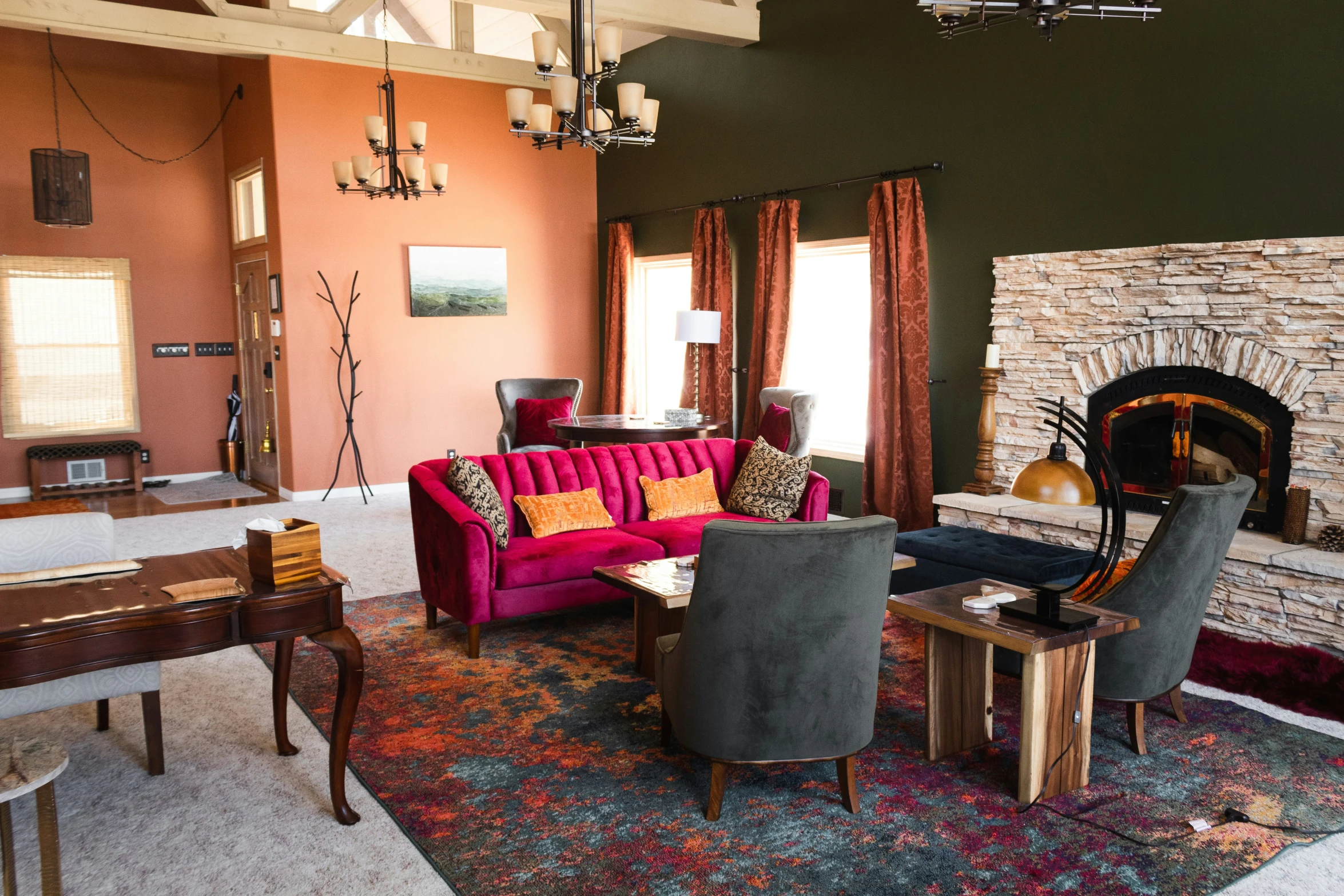 living room with large pink sofa, fireplace, and wooden tables