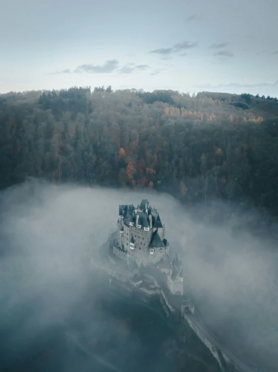 an aerial view of a castle in the fog