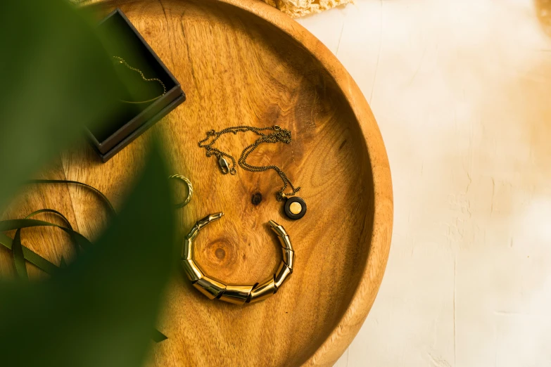 two pairs of earrings on top of a wooden plate