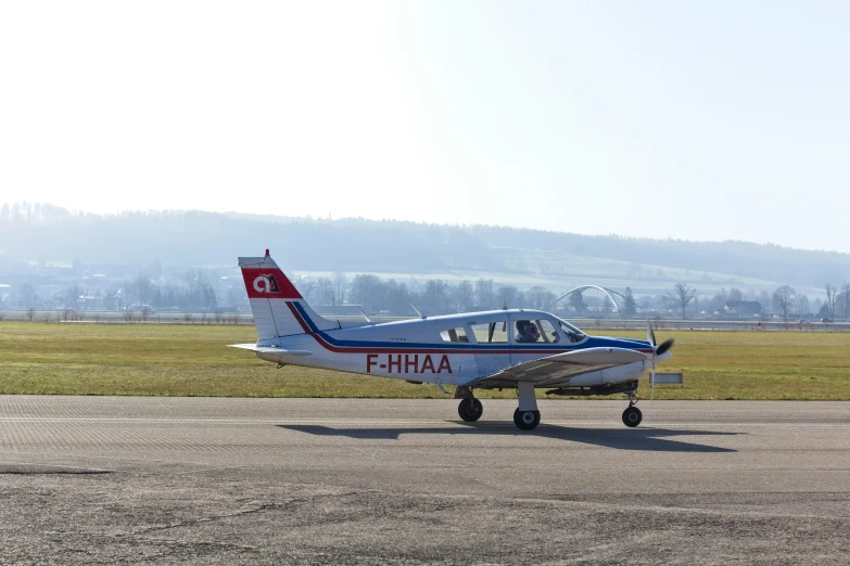 a small blue and white plane on an airport runway