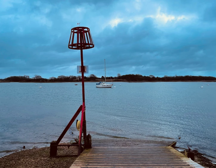 a pier has a light on top and an antenna is at the end