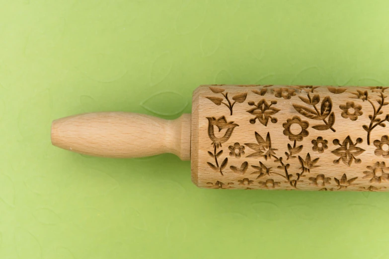 a rolling pin with flowers carved on it