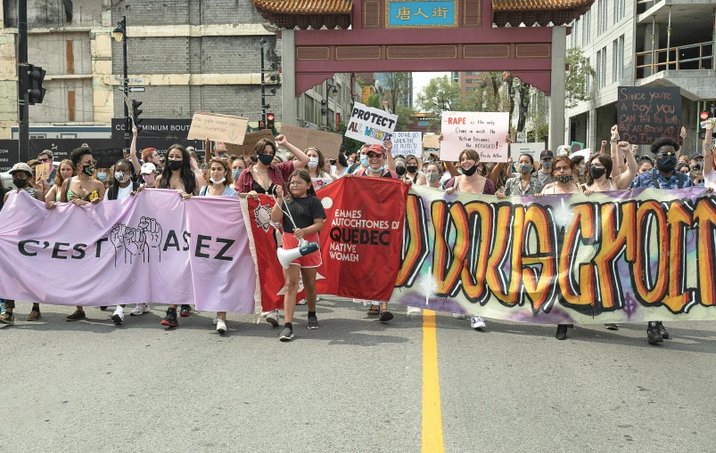 large people hold banners and march down the street