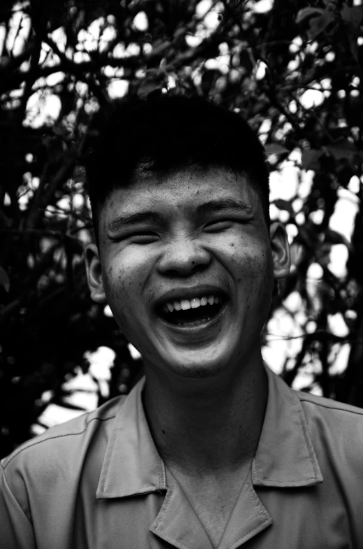 black and white pograph of a boy smiling with eyes open