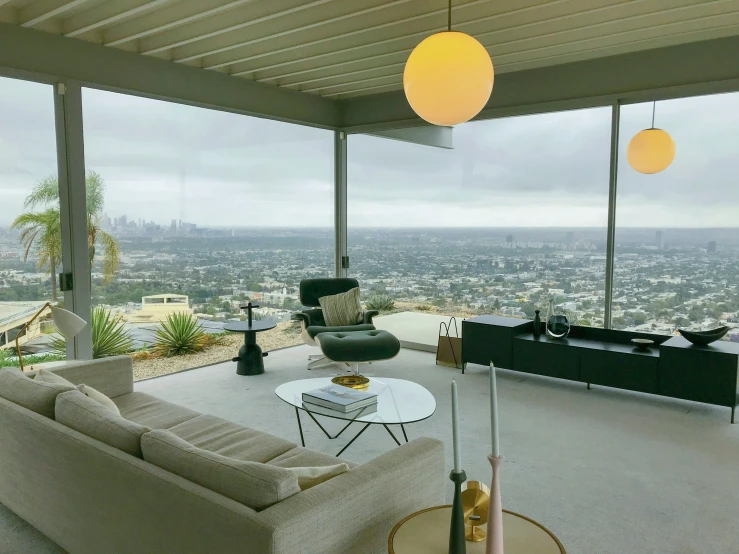 large windowed living room area with two couches facing a city view