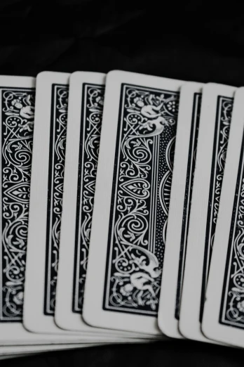 the five playing cards have black writing on them