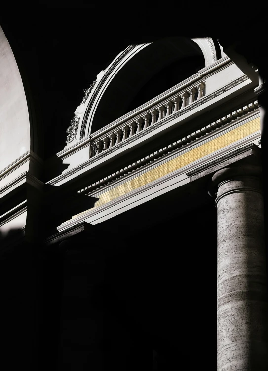 there is an archway in the dark between two stone pillars