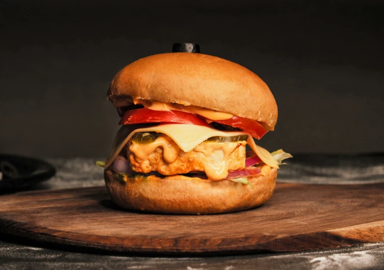 a wooden table holding a cheeseburger that has been cut in half