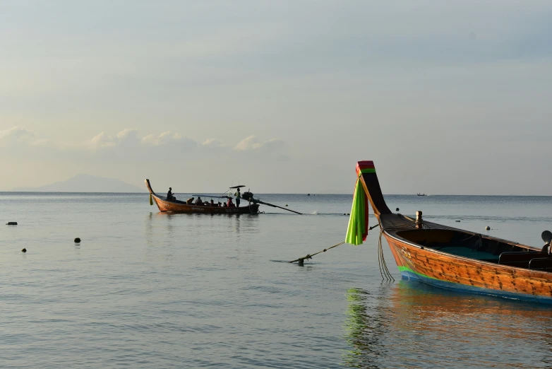 two boats anchored next to each other at the beach