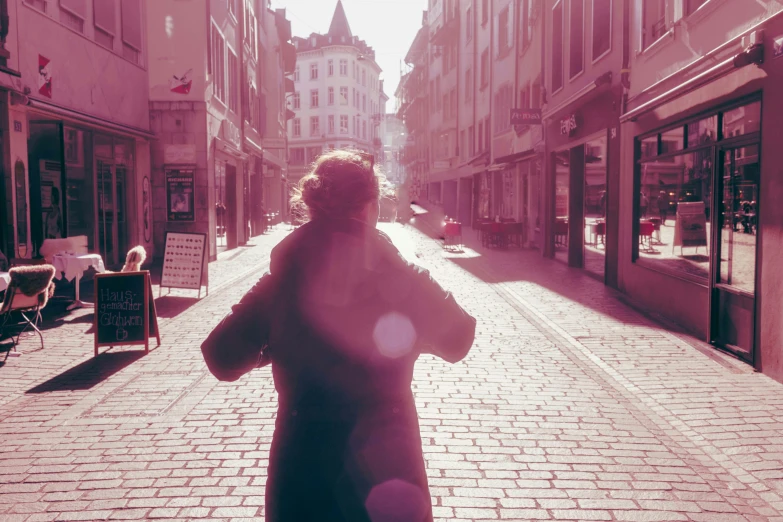 a woman wearing a hat is walking down the street