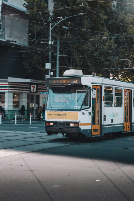 a city bus driving down a street next to a tall building