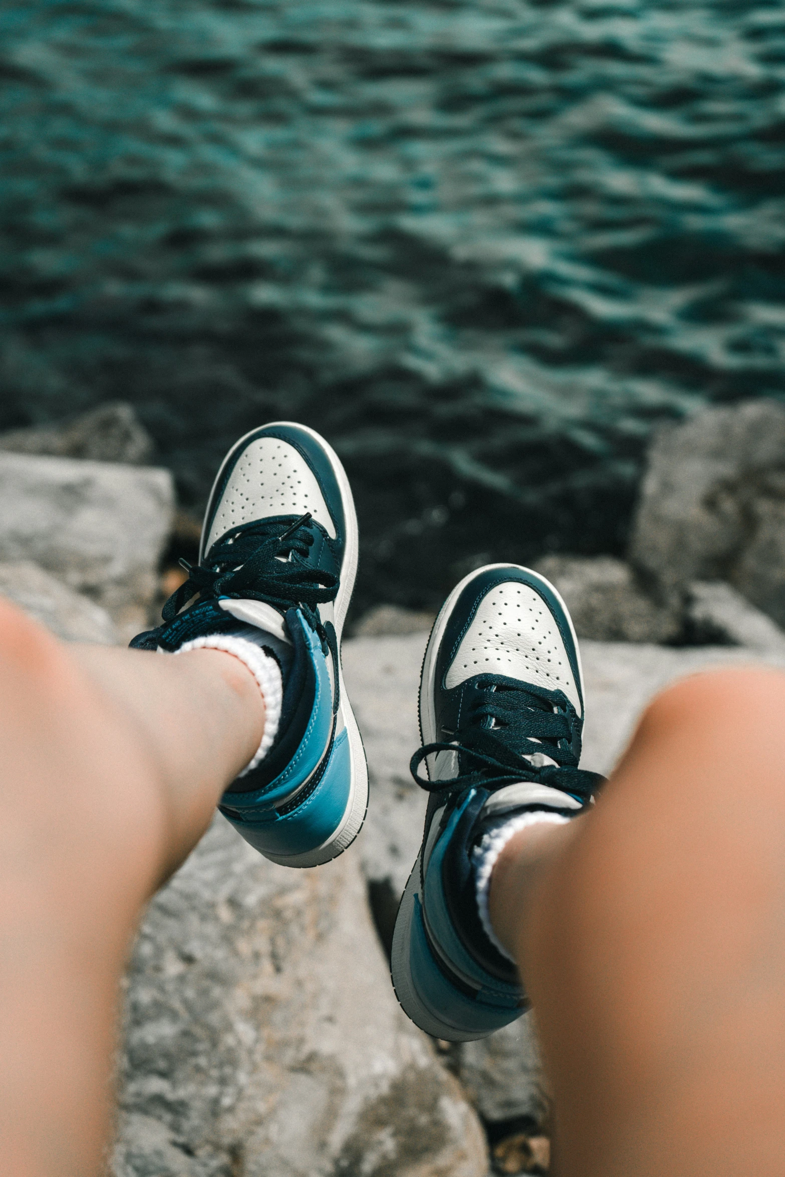 view from a persons feet above water with boat in background