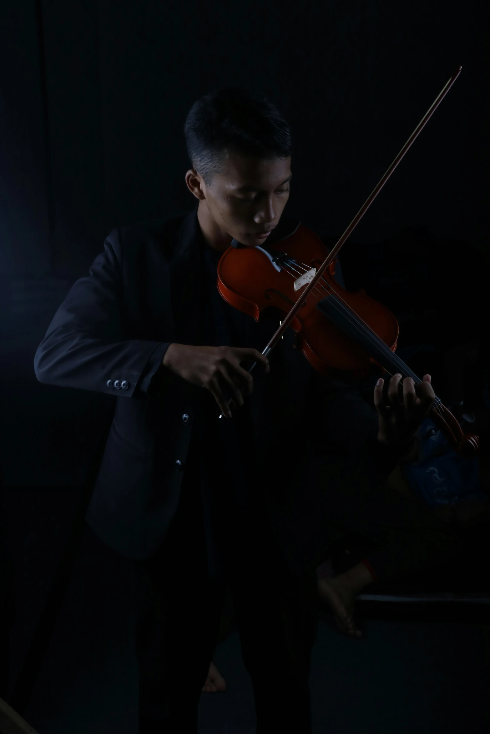 a man playing an instrument in the dark