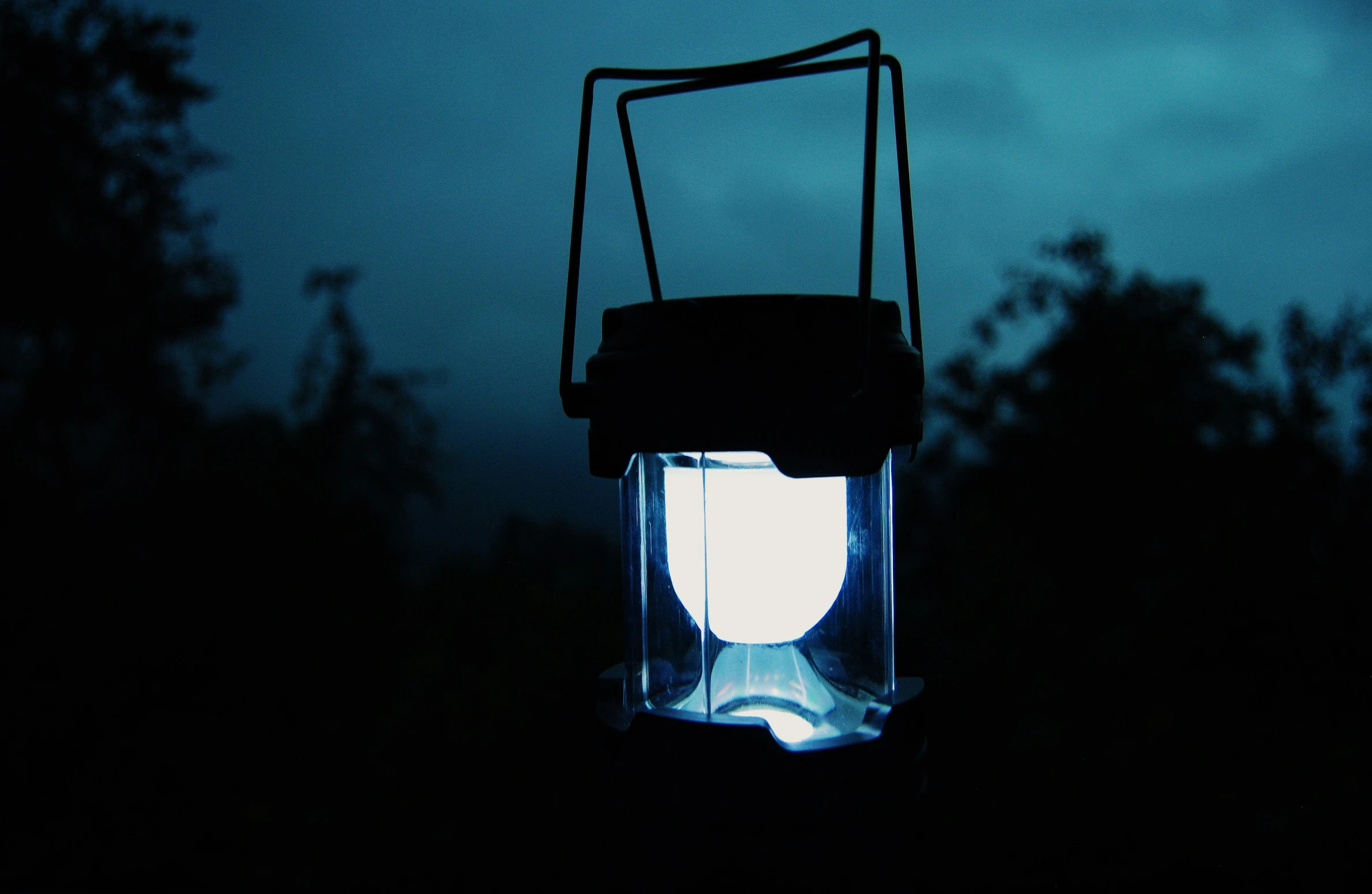 a dark room with a hanging lantern in the middle