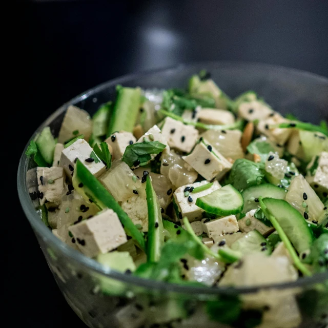 a glass bowl of diced vegetables and green peppers