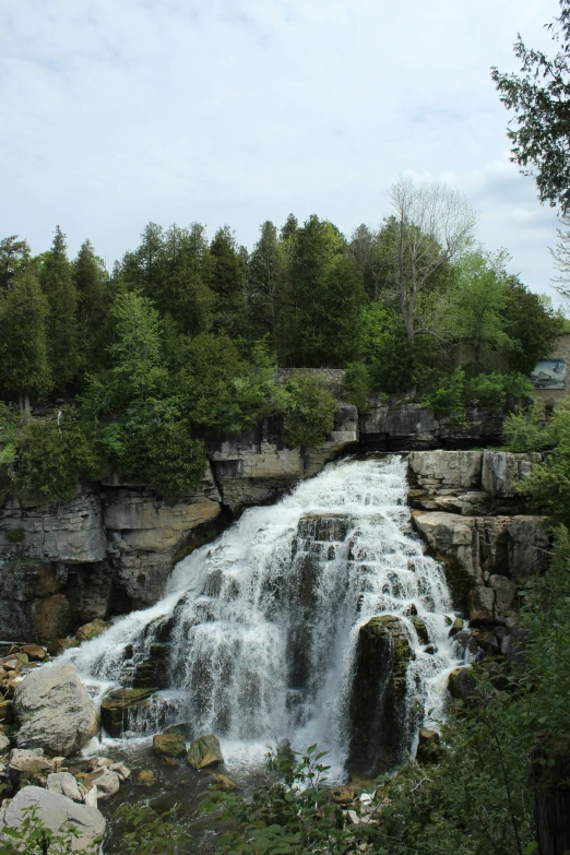 a large waterfall in a river surrounded by woods