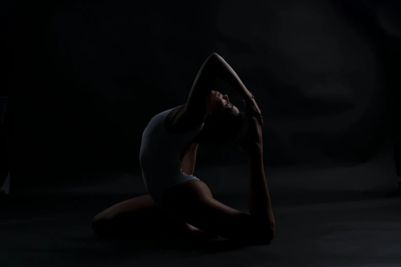 a woman stretching her back in the dark