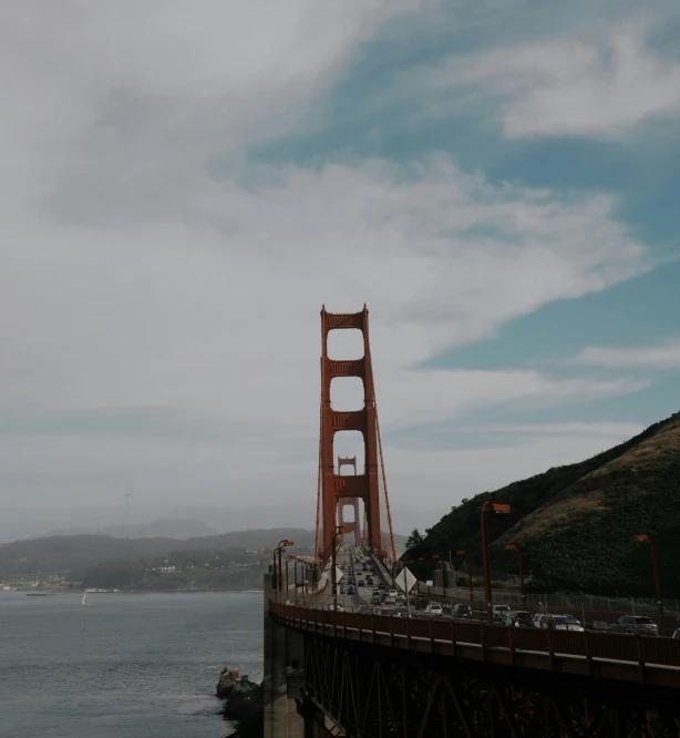 a tall brown bridge stretching into the ocean