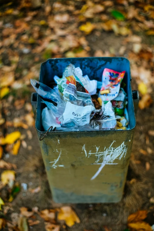 a metal trash can with bags of trash in it