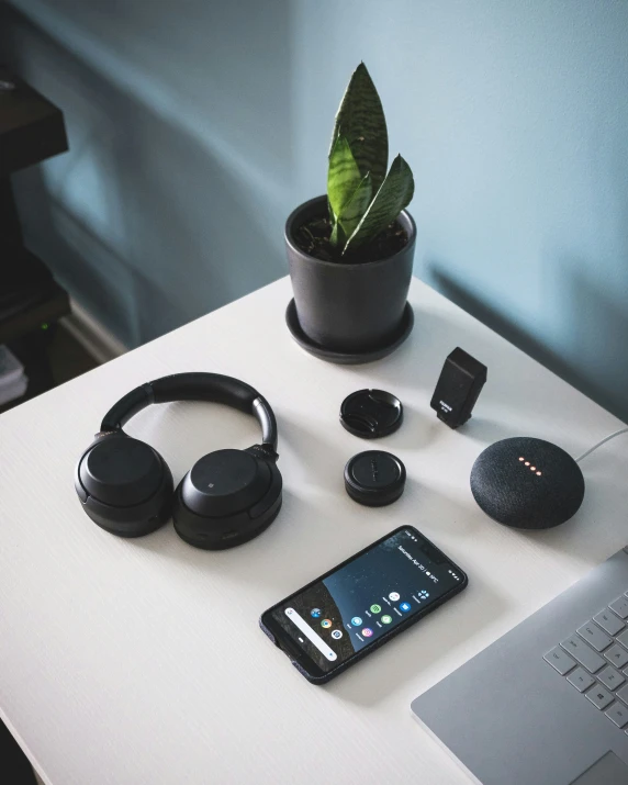 cell phone with a pair of headphones on top of a white desk