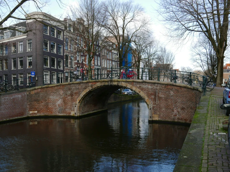 an arched bridge with bikes on it over a river