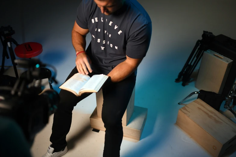 a man is sitting down holding an open book