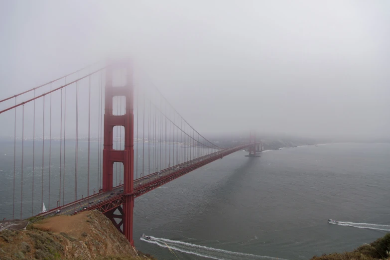 fog enveloping the golden gate bridge as boat comes in