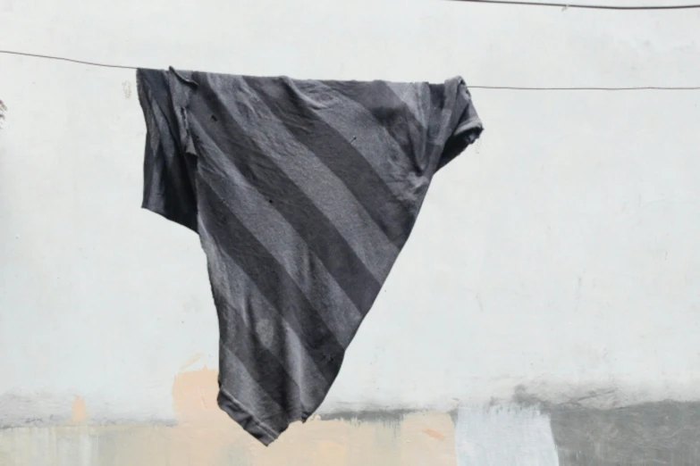 a black and white striped towel hanging from a clothes line