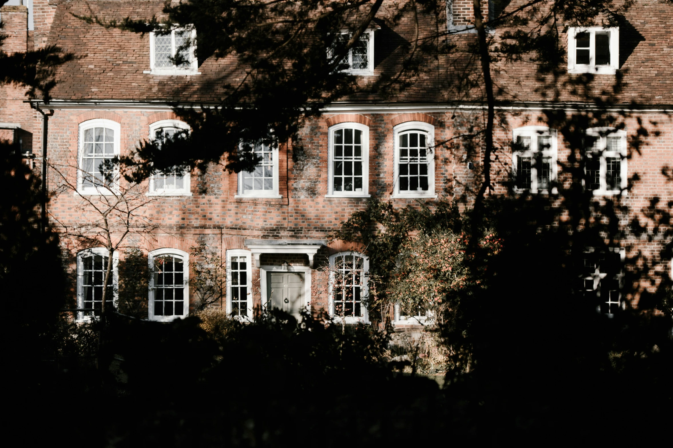 a large red brick building with white shutters