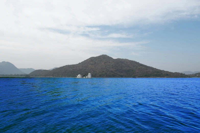 the calm ocean water with some small boats floating on the side