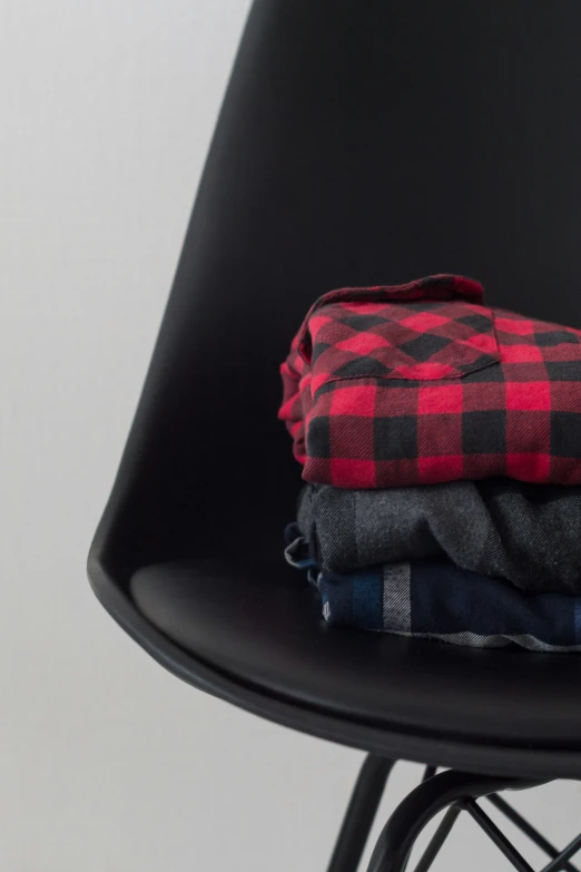 a chair with three shirts on top of it