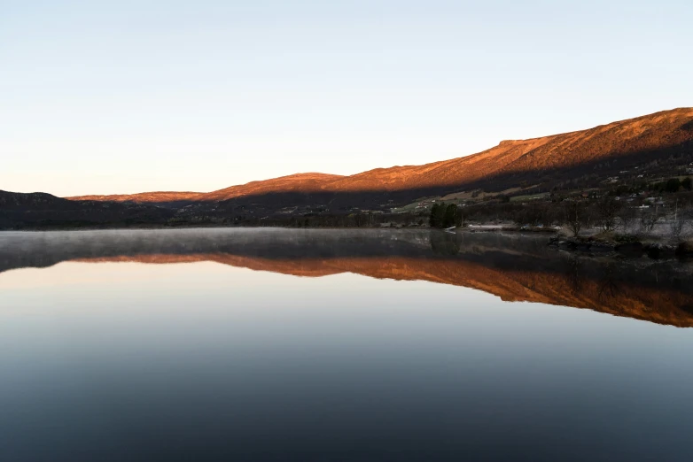 a still lake sits surrounded by a mountain