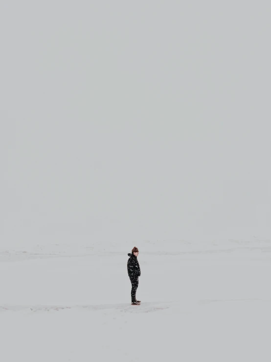 a woman walking in snow with a kite overhead