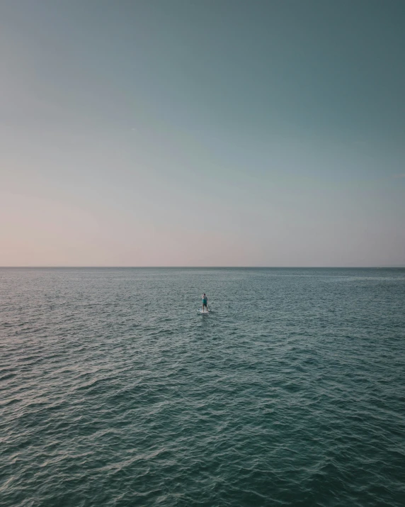 man in the water swimming in the distance