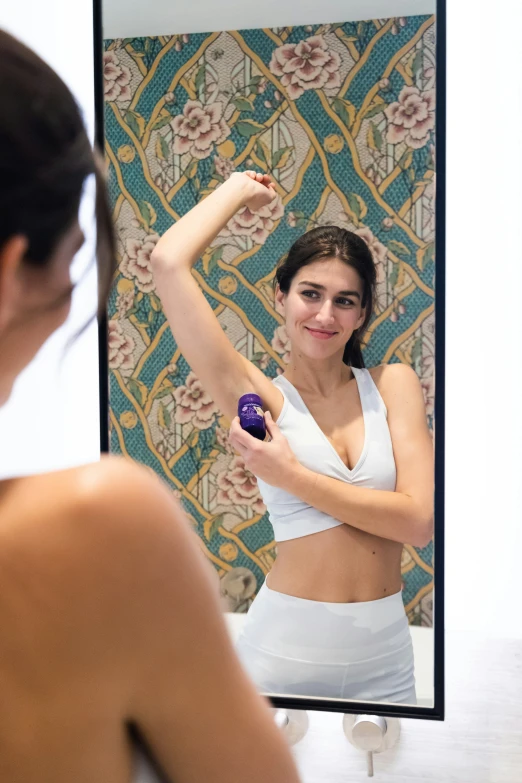 a woman brushing her hair while standing in front of a mirror