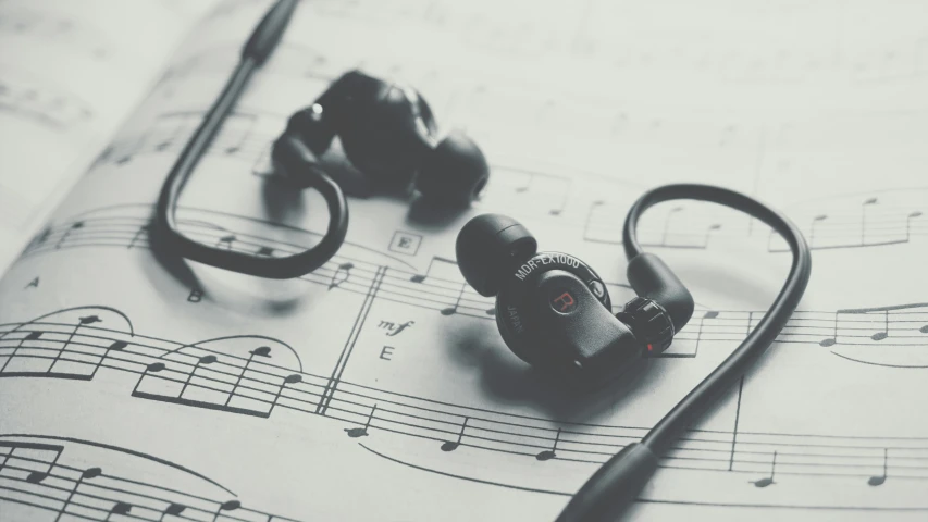 a pair of headphones sitting on top of a sheet of music