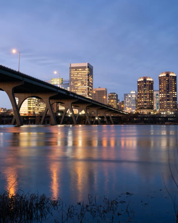 a river scene with a bridge and tall buildings in the background