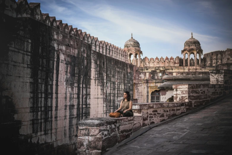 a person with a buddha statue on a ledge above water