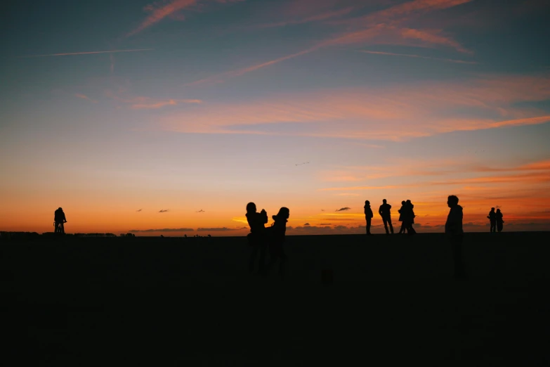 there is a group of people standing together at sunset