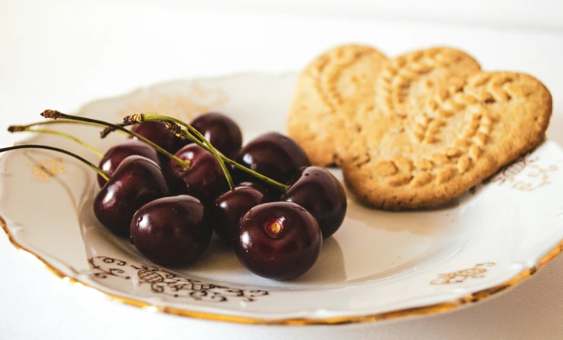 a plate with cookies and plums on it