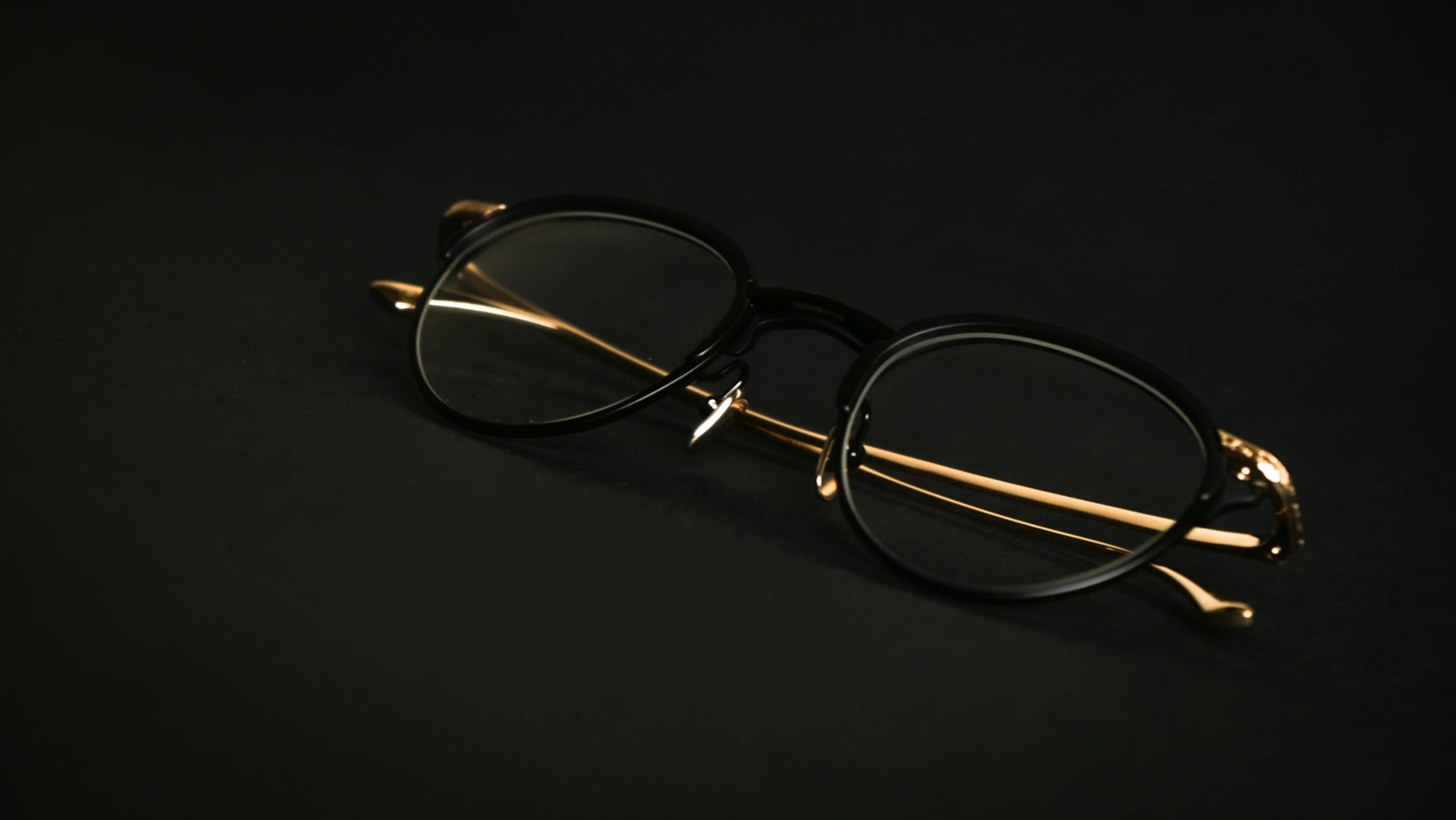 the black frame of a pair of glasses with gold accents