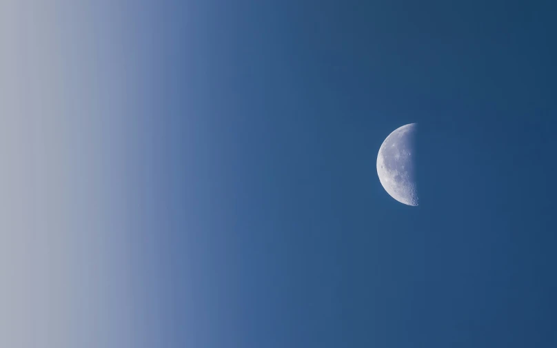 a quarter moon in the blue sky