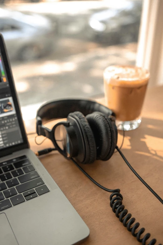 an open laptop computer on a desk with headphones