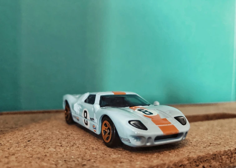 toy car with orange stripes parked on the side of the road