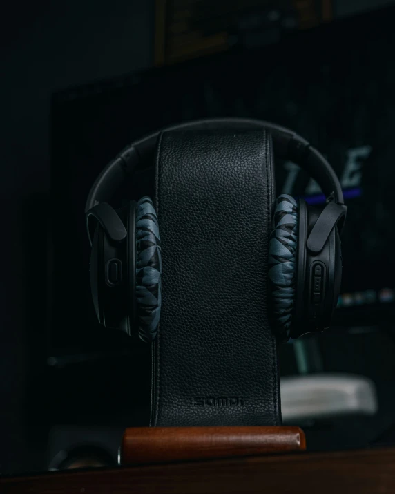 a black headphone is attached to a wooden table